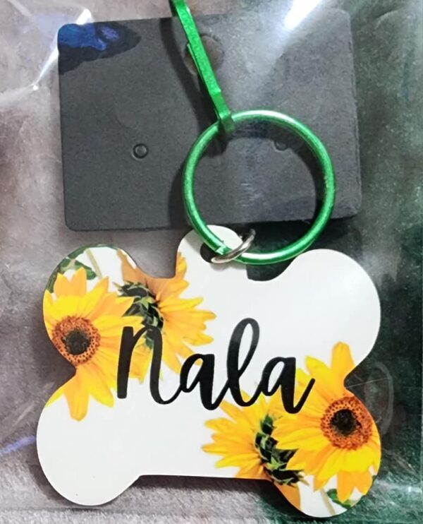 Product image of a dog tag pet ID tag with the name "Nala" written in cursive. Product is packaged.